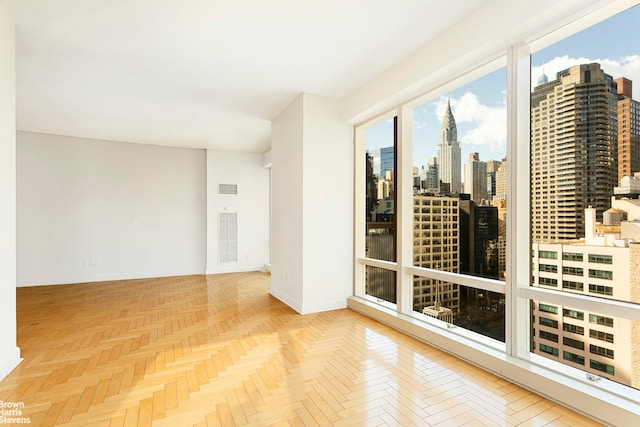 empty room with a city view, baseboards, and visible vents