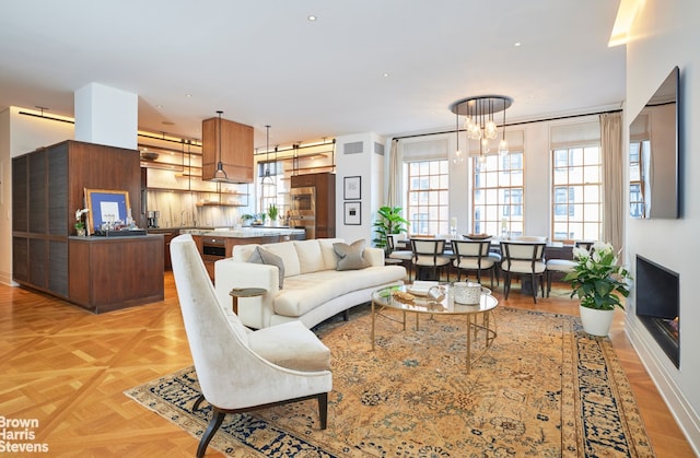 living room with light parquet flooring and a chandelier