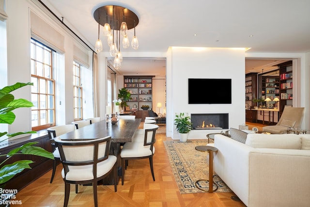 dining room with a warm lit fireplace and a chandelier