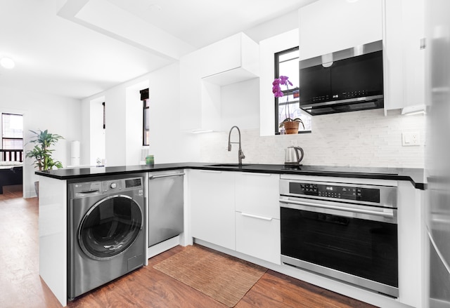 kitchen with washer / clothes dryer, appliances with stainless steel finishes, white cabinetry, modern cabinets, and a peninsula