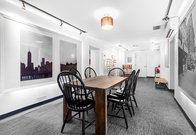 dining area featuring rail lighting and baseboards