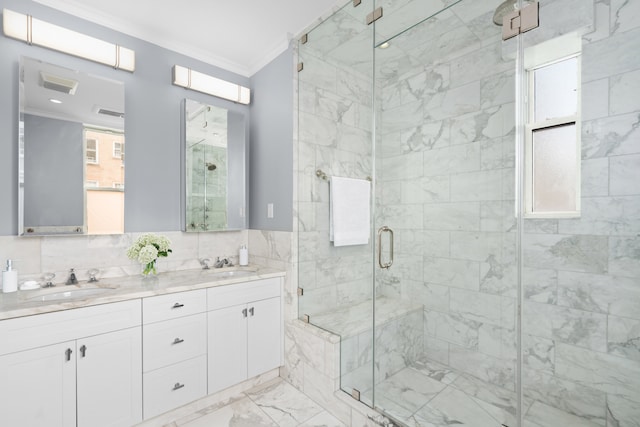 full bath with a sink, marble finish floor, a stall shower, and ornamental molding