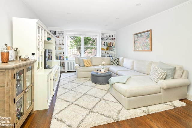 living room featuring radiator, crown molding, built in shelves, and dark wood-style flooring