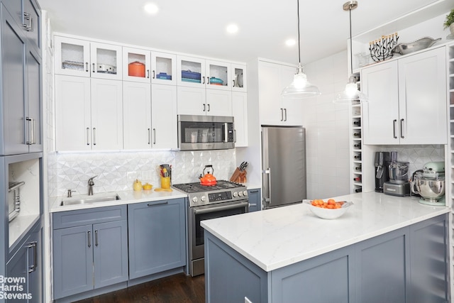 64 E 94th St Unit 3C, New York City, NY 10128 - kitchen with appliances with stainless steel finishes, a peninsula, backsplash, a sink, and white cabinetry