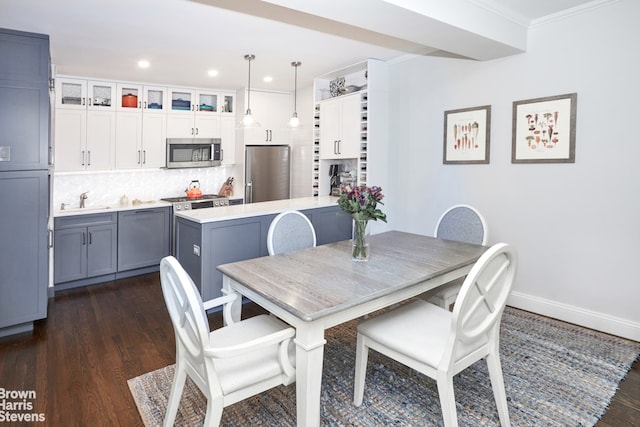 dining area with dark wood-style flooring, crown molding, baseboards, and recessed lighting