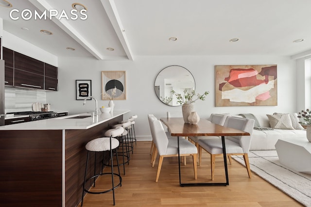 dining area with recessed lighting, beam ceiling, light wood-style flooring, and baseboards