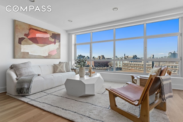 living area with a city view, plenty of natural light, and wood finished floors