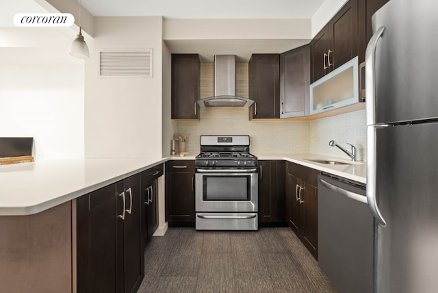 kitchen with stainless steel appliances, visible vents, light countertops, a sink, and wall chimney range hood