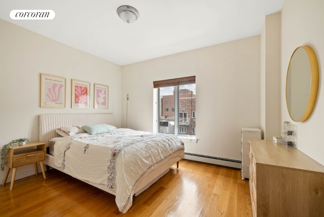 bedroom featuring light wood-style floors, visible vents, and baseboard heating