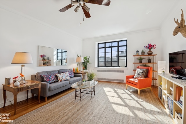 living room with a healthy amount of sunlight, radiator, and hardwood / wood-style floors