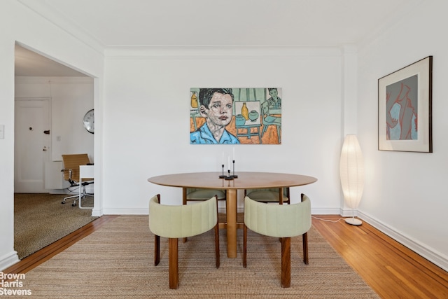 dining area with ornamental molding and wood-type flooring