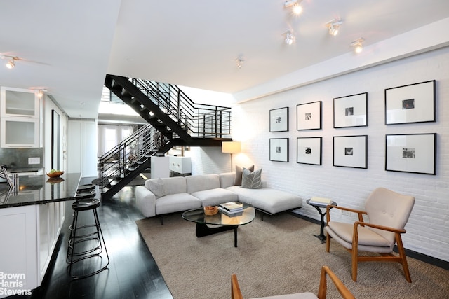 living room featuring dark wood-type flooring and track lighting