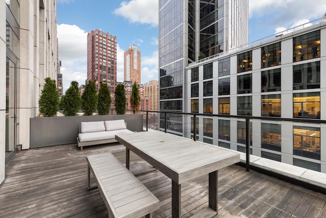 wooden terrace featuring a view of city and an outdoor hangout area