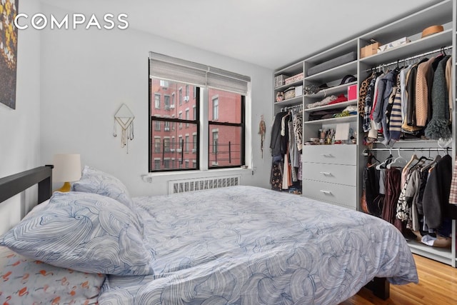 bedroom with hardwood / wood-style flooring and radiator