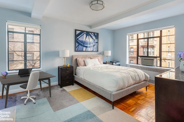 bedroom featuring beamed ceiling, radiator heating unit, cooling unit, and light parquet floors