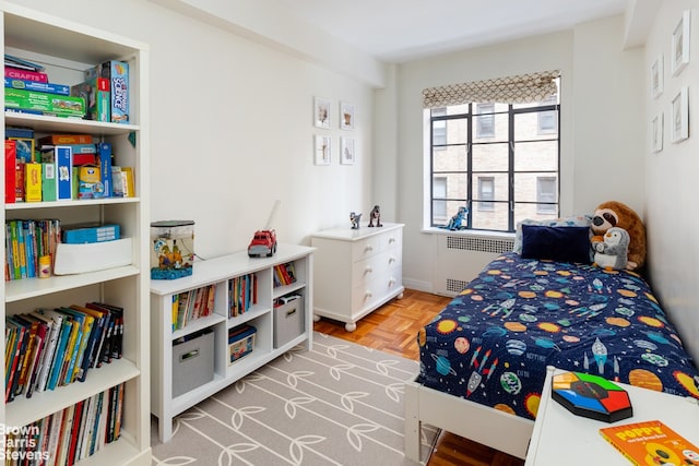 bedroom featuring radiator and light parquet floors