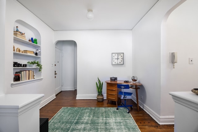 home office featuring dark hardwood / wood-style flooring and built in features