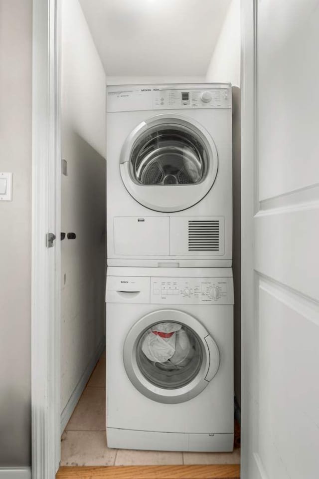 washroom featuring stacked washer and dryer and laundry area