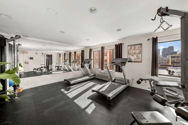 workout area featuring recessed lighting, baseboards, and a view of city