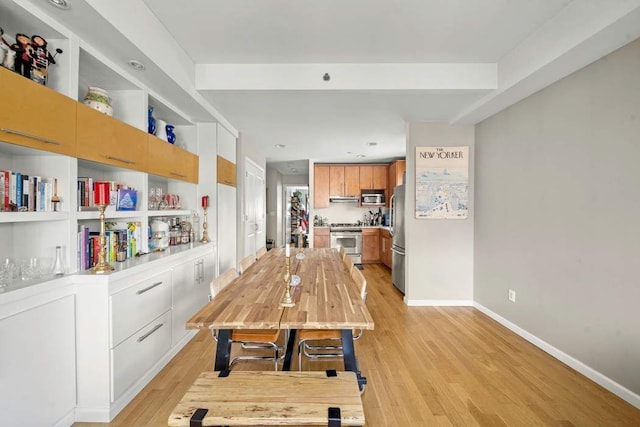 dining room with light wood-style floors and baseboards
