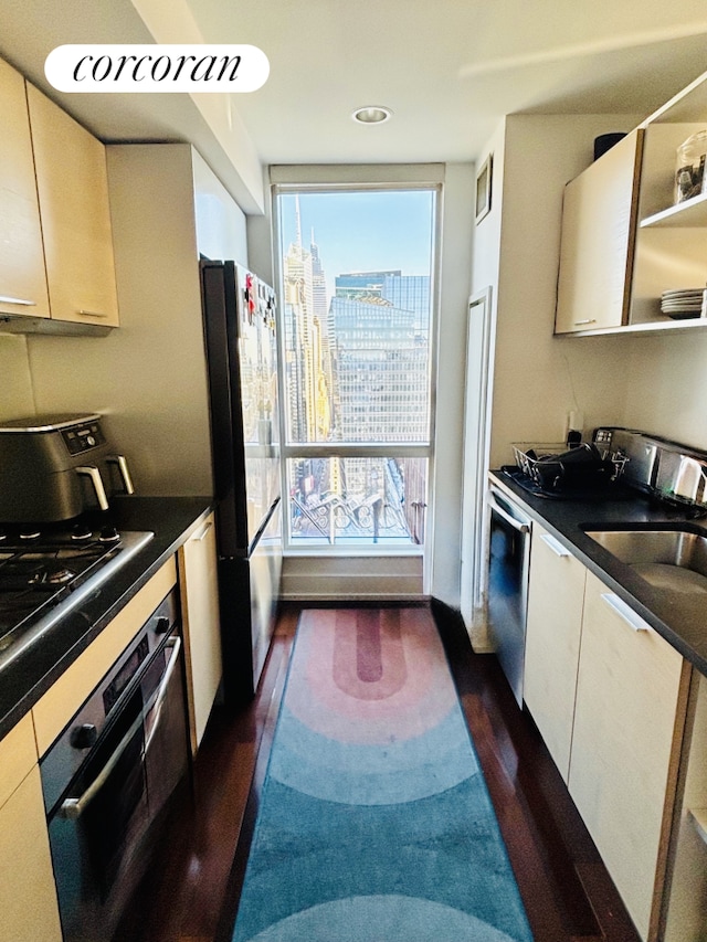 kitchen with dark wood-style flooring, freestanding refrigerator, wall oven, stainless steel dishwasher, and dark countertops