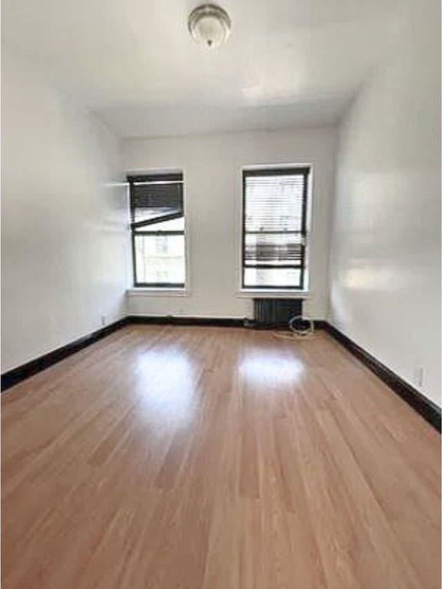 spare room featuring wood finished floors and baseboards