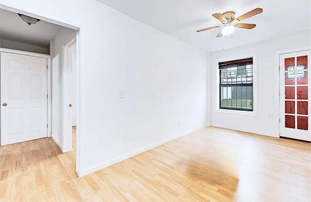 unfurnished room with light wood-style floors, ceiling fan, and baseboards