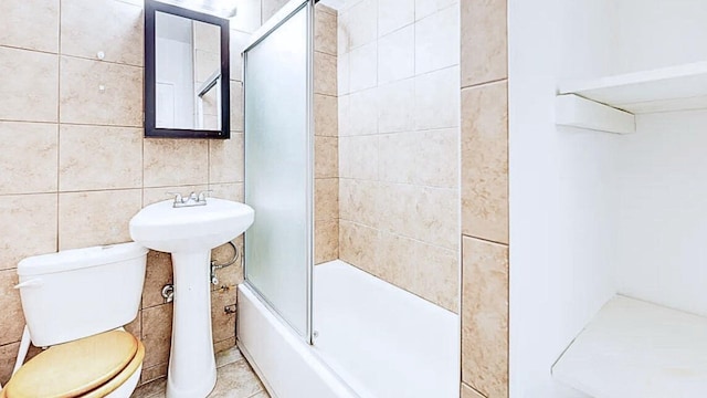full bath featuring tile walls and toilet