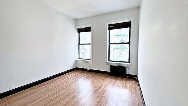 unfurnished room with baseboards and wood finished floors