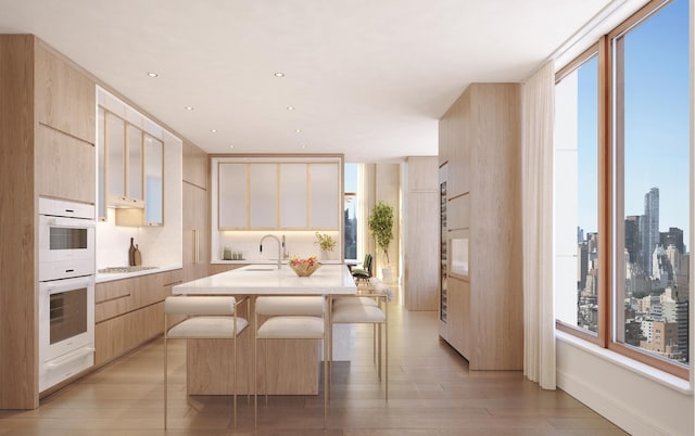 kitchen with light countertops, modern cabinets, a sink, and light wood-style flooring