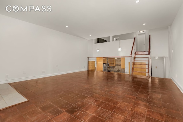 unfurnished living room featuring a high ceiling