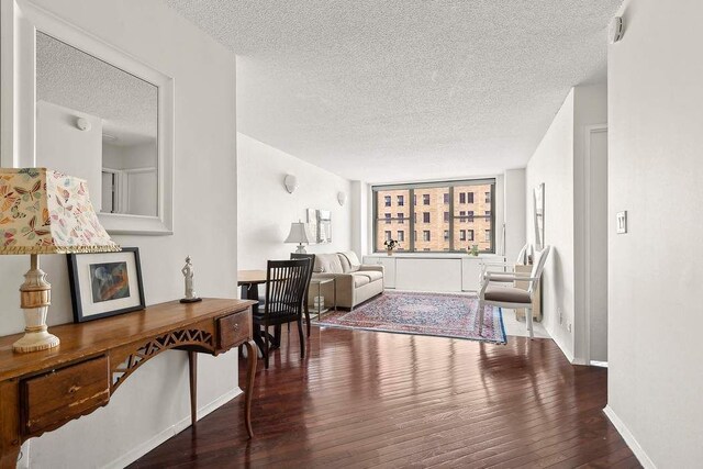 living room with dark hardwood / wood-style flooring and a textured ceiling