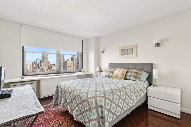 bedroom featuring dark hardwood / wood-style floors and a textured ceiling