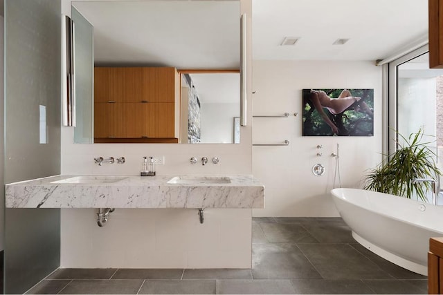 bathroom featuring double sink and a washtub