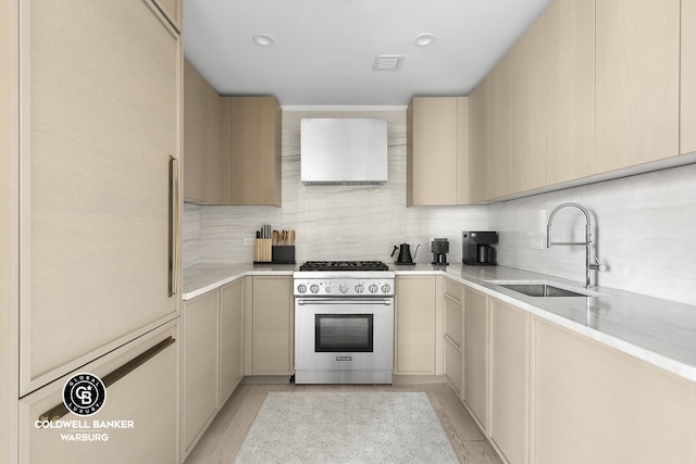 1399 Park Ave Unit 8D, New York City, NY 10029 - kitchen featuring high end stove, a sink, range hood, and tasteful backsplash
