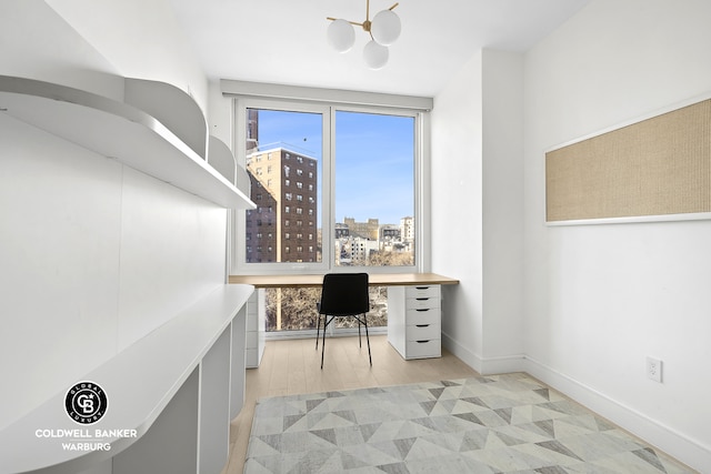 1399 Park Ave Unit 8D, New York City, NY 10029 - home office with light wood-style floors, a chandelier, a city view, and baseboards