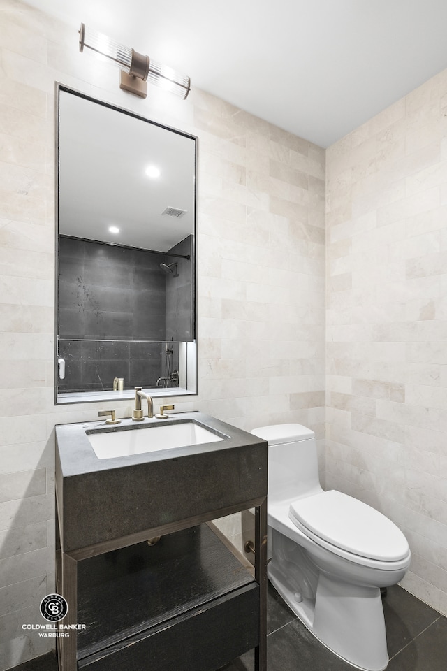 1399 Park Ave Unit 8D, New York City, NY 10029 - bathroom with tile walls, toilet, vanity, and tile patterned floors