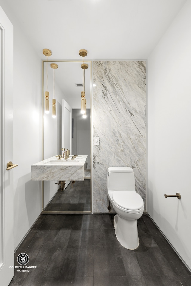 1399 Park Ave Unit 8D, New York City, NY 10029 - half bathroom featuring toilet, a sink, wood finished floors, and tile walls
