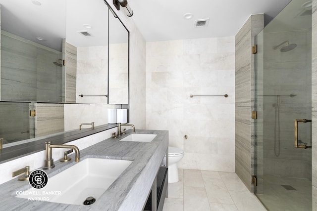 1399 Park Ave Unit 8D, New York City, NY 10029 - bathroom featuring tile walls, a shower stall, toilet, double vanity, and tile patterned floors
