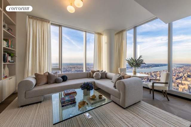 living room with expansive windows, a water view, and parquet floors