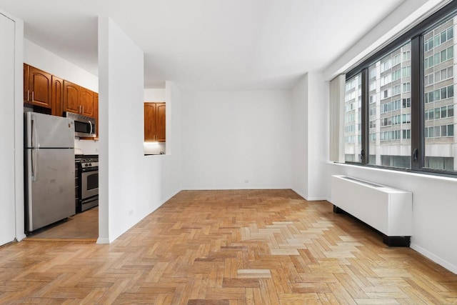 empty room featuring light parquet flooring and radiator heating unit