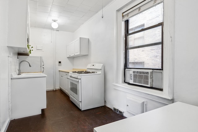 kitchen with white range with gas stovetop, a sink, white cabinets, light countertops, and cooling unit