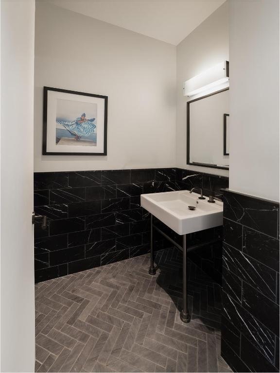 bathroom featuring sink and tile walls