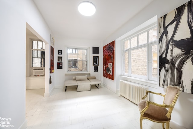 sitting room with radiator, cooling unit, and baseboards