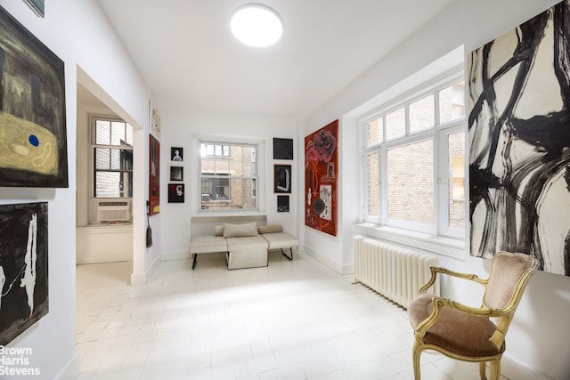 sitting room featuring cooling unit, baseboards, and radiator heating unit