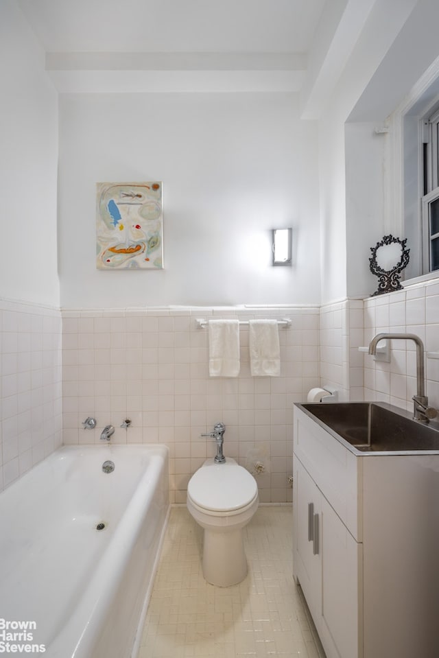 full bath with a garden tub, toilet, wainscoting, tile walls, and vanity