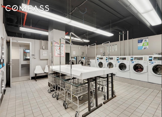 laundry area with washing machine and clothes dryer and tile patterned floors