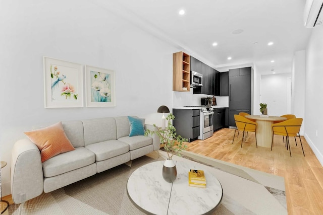 living room featuring light wood finished floors, recessed lighting, baseboards, and a wall unit AC