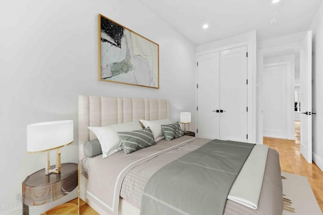 bedroom featuring recessed lighting, wood finished floors, and a closet