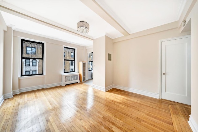 spare room featuring a notable chandelier, crown molding, and light hardwood / wood-style floors